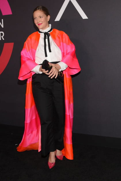 Drew Barrymore en pantalon noir, chemise blanche et cape colorée