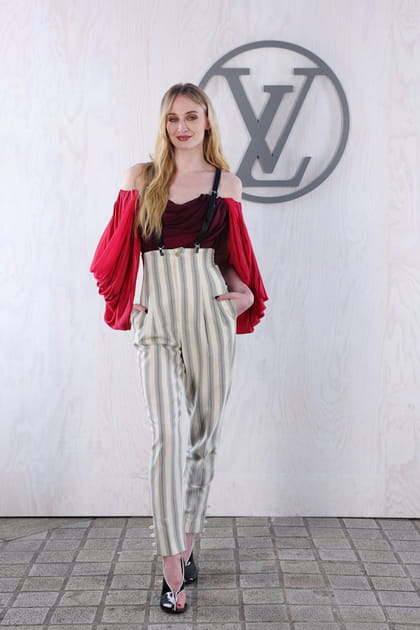 Sophie Turner en blouse &agrave; &eacute;paules d&eacute;gag&eacute;es et pantalon &agrave; rayures verticales