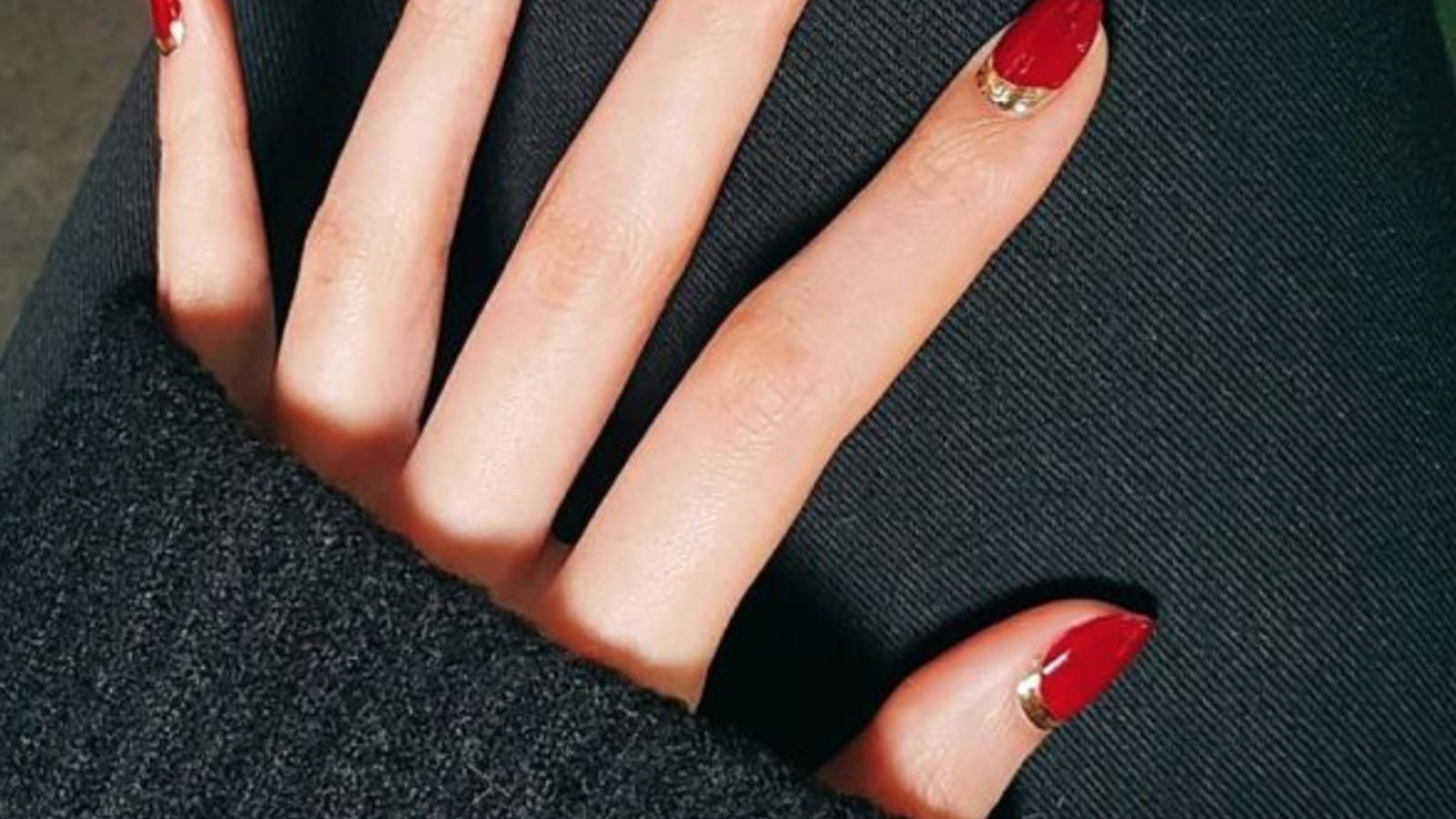 Des ongles rouges avec une touche dorée