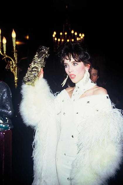 Isabelle Adjani en manteau blanc à plumes et robe longue &agrave; d&eacute;coupes