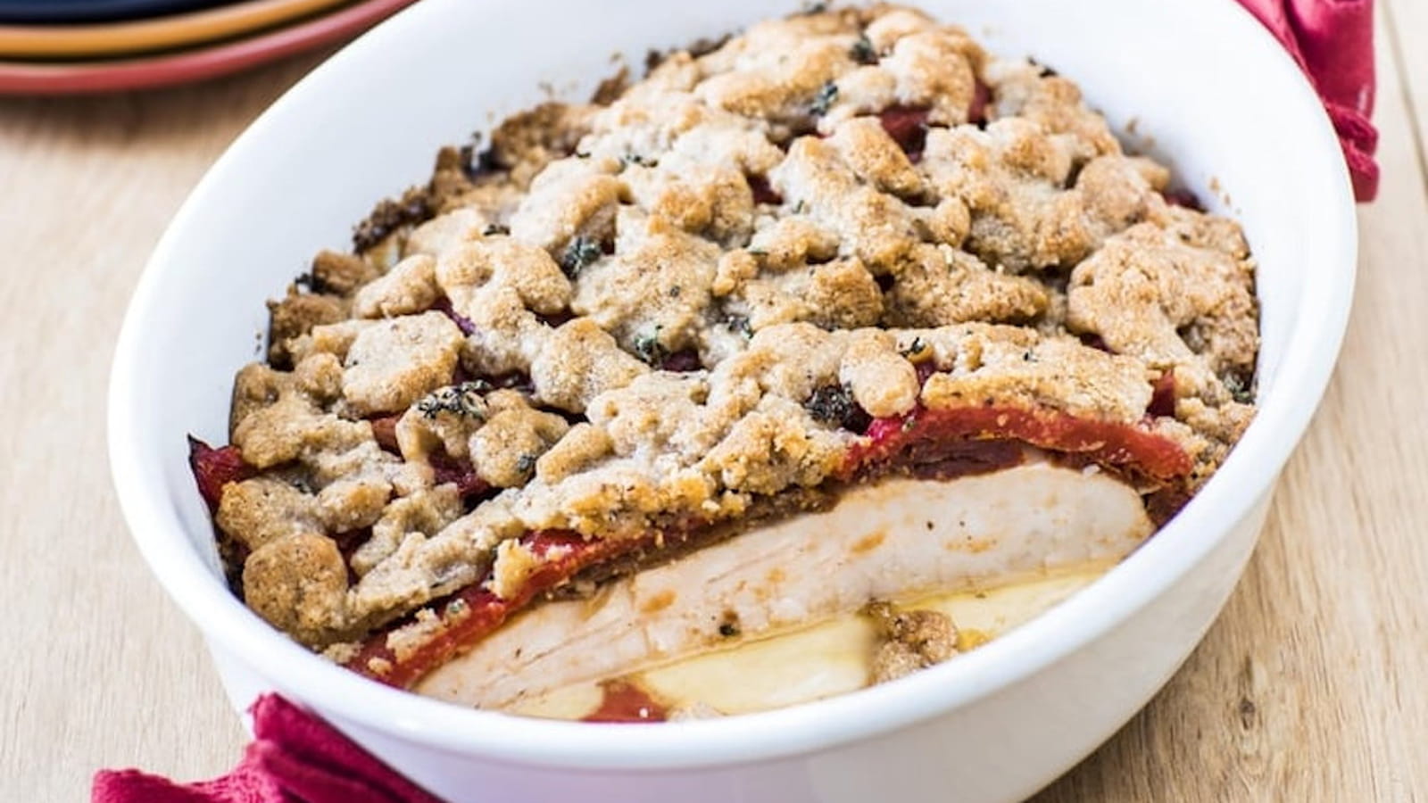 Crumble de noisettes et de parmesan, filets de poulet Père Dodu aux poivrons aillés et aux tomates confites