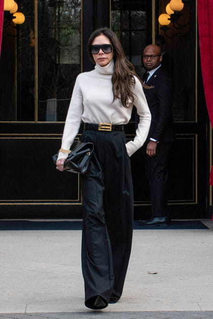 Victoria Beckham en pull crème à col roulé et pantalon large de costume