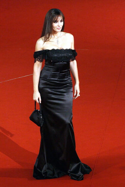 Monica Bellucci en robe noire en velours à encolure Bardot et mini sac à main