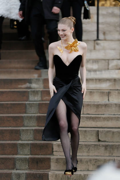 Hunter Schafer en robe bustier noire et collier graphique dor&eacute; au d&eacute;fil&eacute; Schiaparelli haute couture printemps-&eacute;t&eacute; 2024