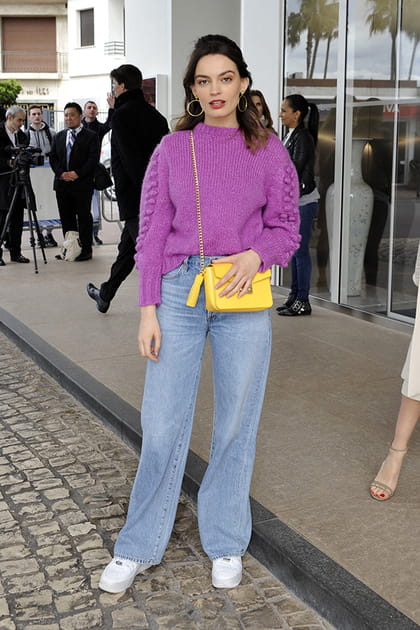 Emma Mackey en pull violet et sac &agrave; main jaune