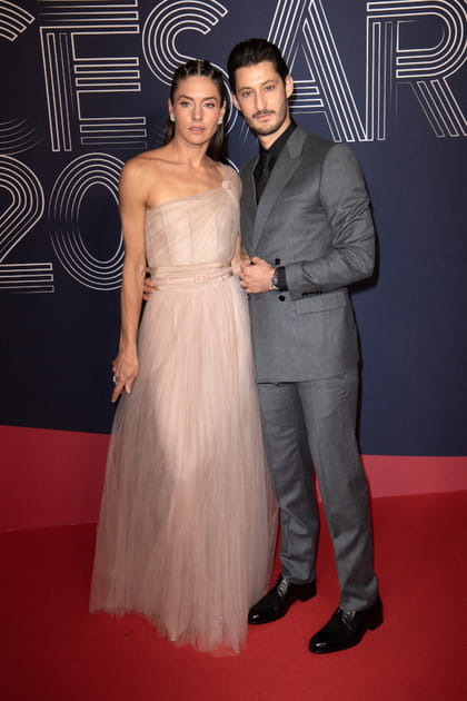 Pierre Niney et Natasha Andrews en costume gris et robe rose poudr&eacute;