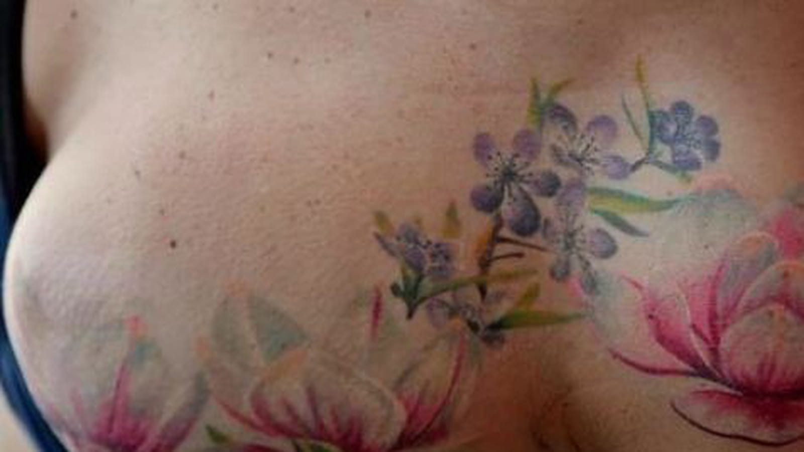 Fleurs de lotus sur le sein et l'épaule