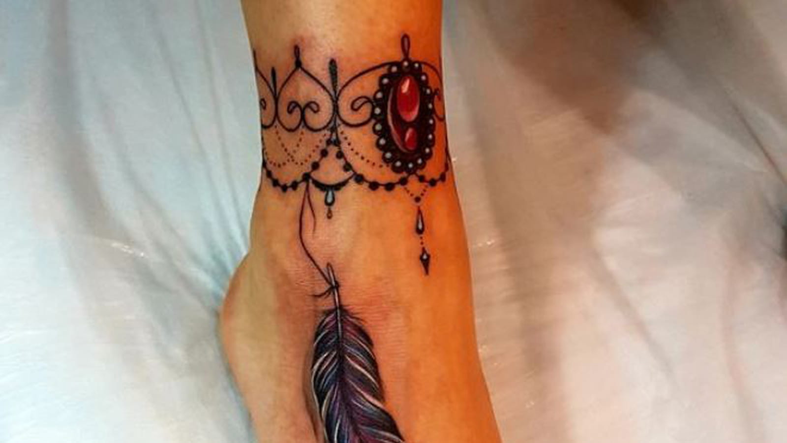 Tatouage plume sur le pied
