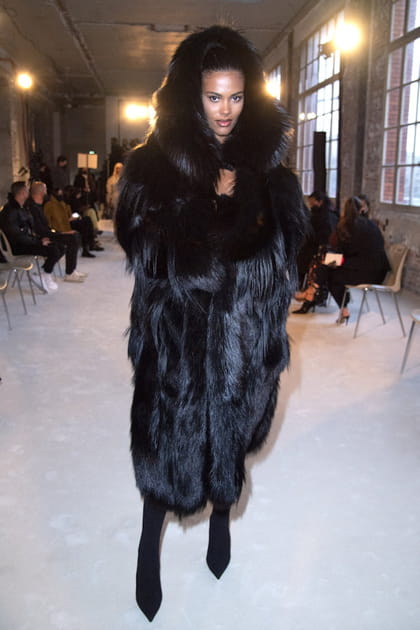 Tina Kunakey dans un manteau de fourrure noire &agrave; capuche