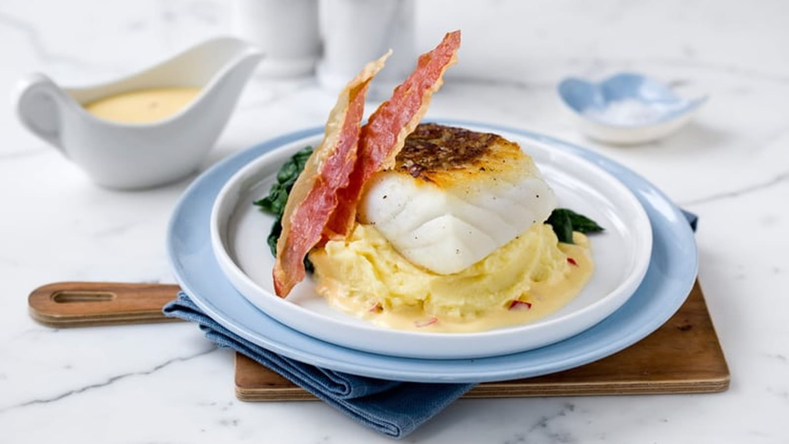 Cabillaud Skrei sur purée de pommes de terre, sauce à l’orange et chips de jambon de Parme