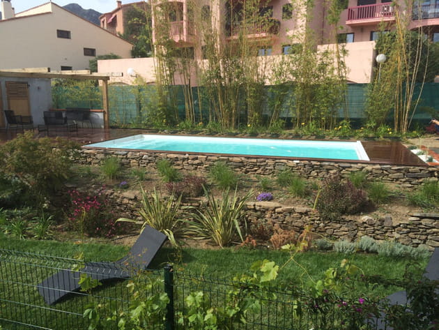 Une piscine installée dans un jardin en paliers