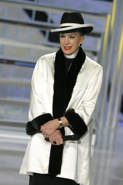 Geneviève de Fontenay en chapeau bicolore et veste blanche brodée de fourrure