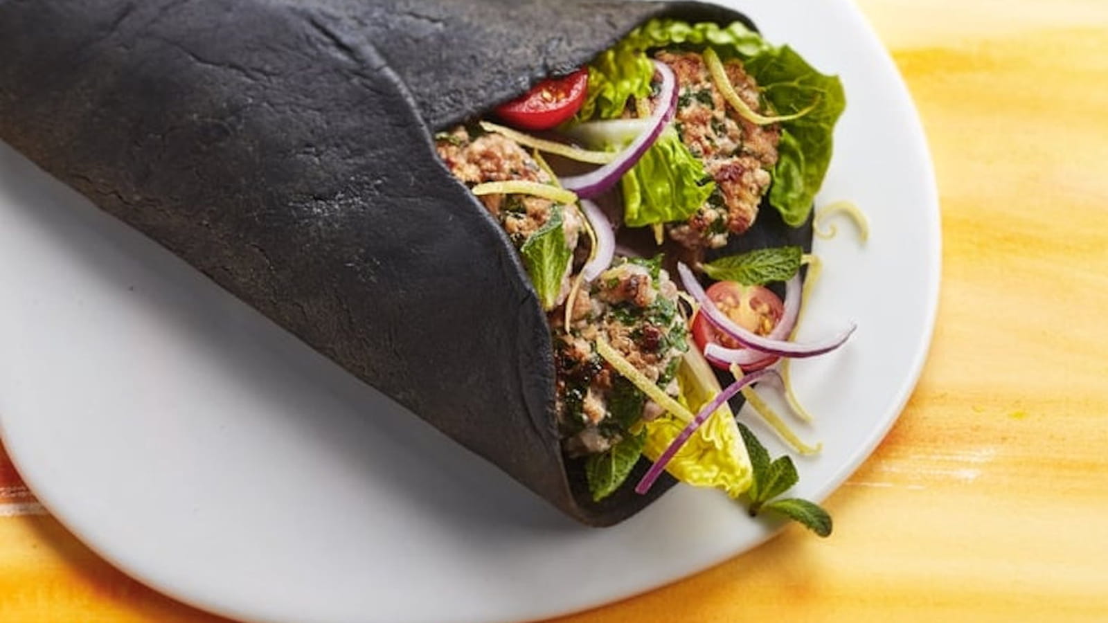Pita à l'encre de seiche, haché de veau, aubergine grillée et bergamote