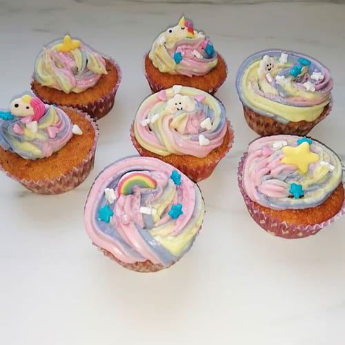 Muffins aux fruits rouges et glaçage arc en ciel