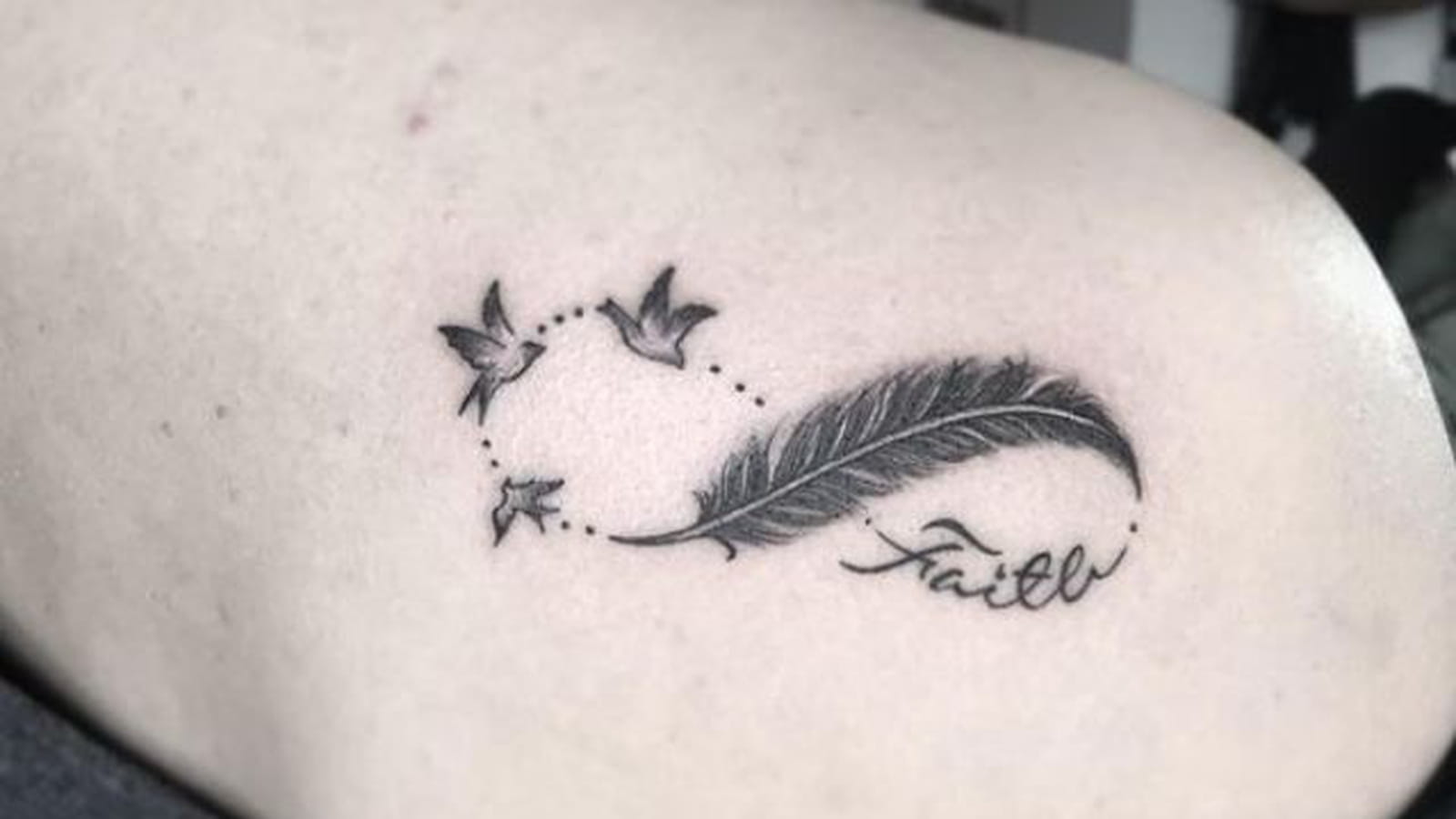 Plume et espoir infini sur l'omoplate