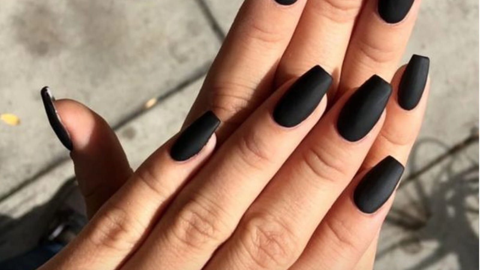Une manucure avec du vernis noir matte