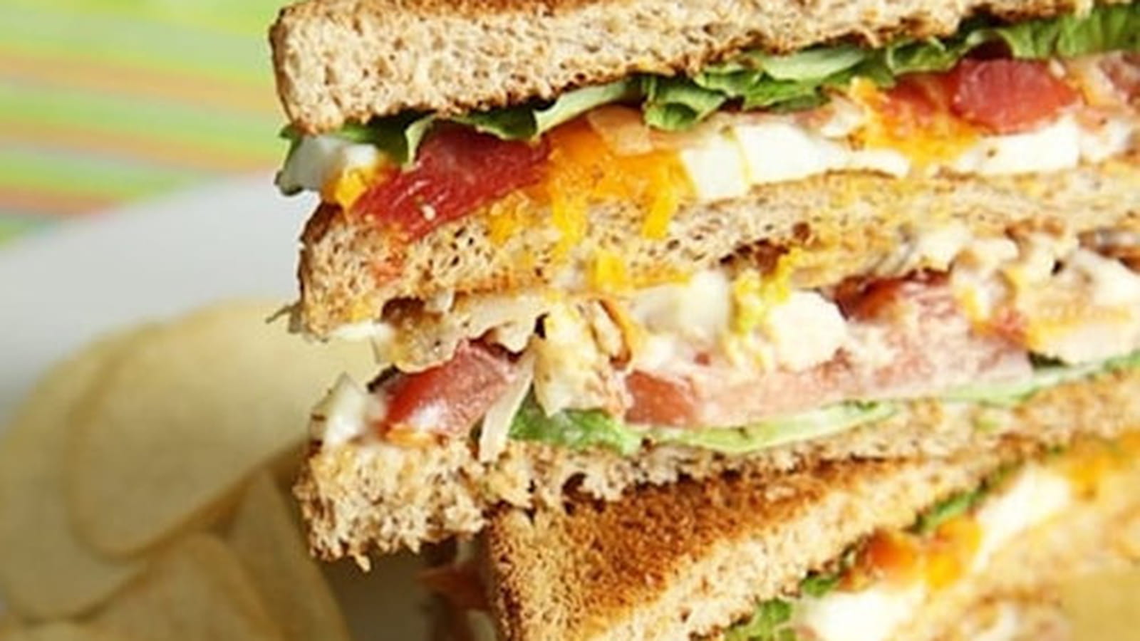 Club sandwich poulet rôti, bacon, oeuf, tomates
