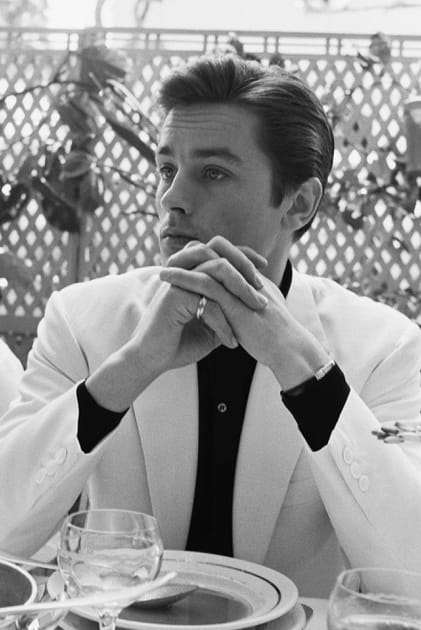 Alain Delon en costume blanc et chemise noire