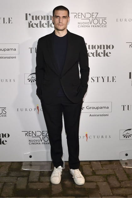 Louis Garrel en costume noir et baskets blanches
