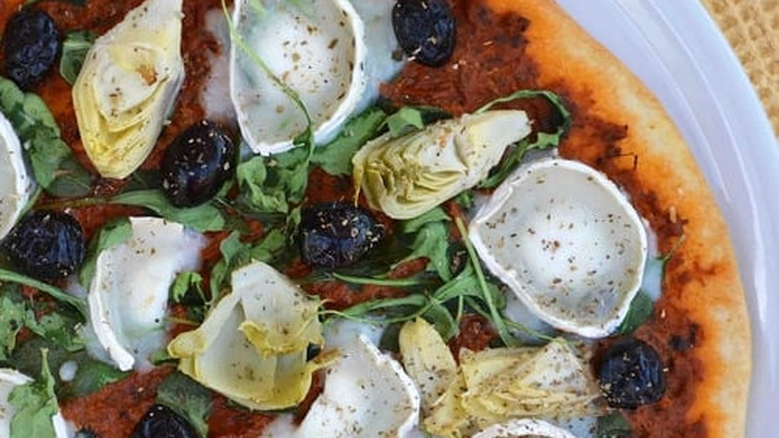 Pizza au pesto rouge, artichaut, fromage de chèvre et roquette