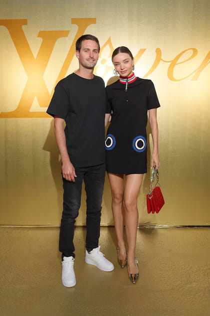 Miranda Kerr en mini robe noire à col montant et Evan Spiegel en T-shirt noir et jean slim