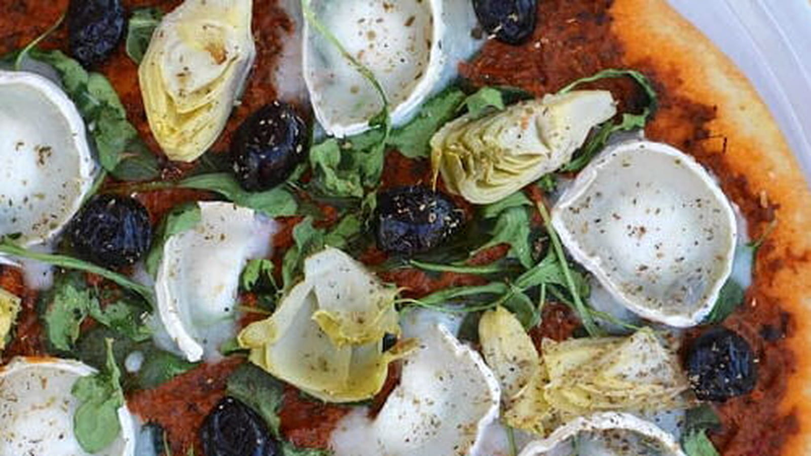 Pizza au pesto rouge, artichaut, fromage de chèvre et roquette