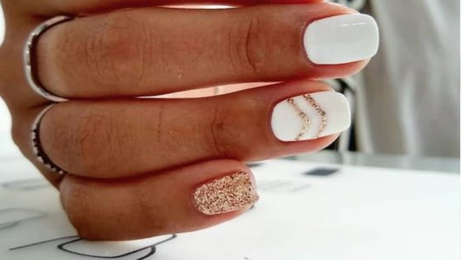 Des ongles blancs avec des détails dorés