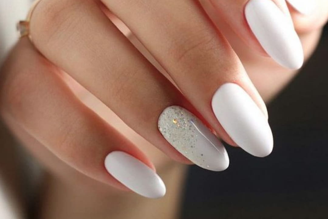Des ongles blancs avec un ongle pailletté