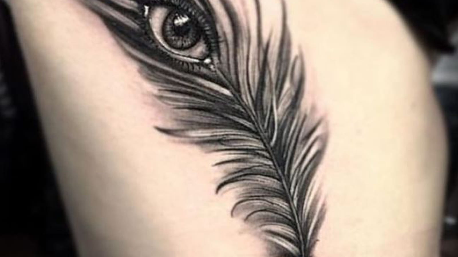 Tatouage plume et oeil sur le flanc