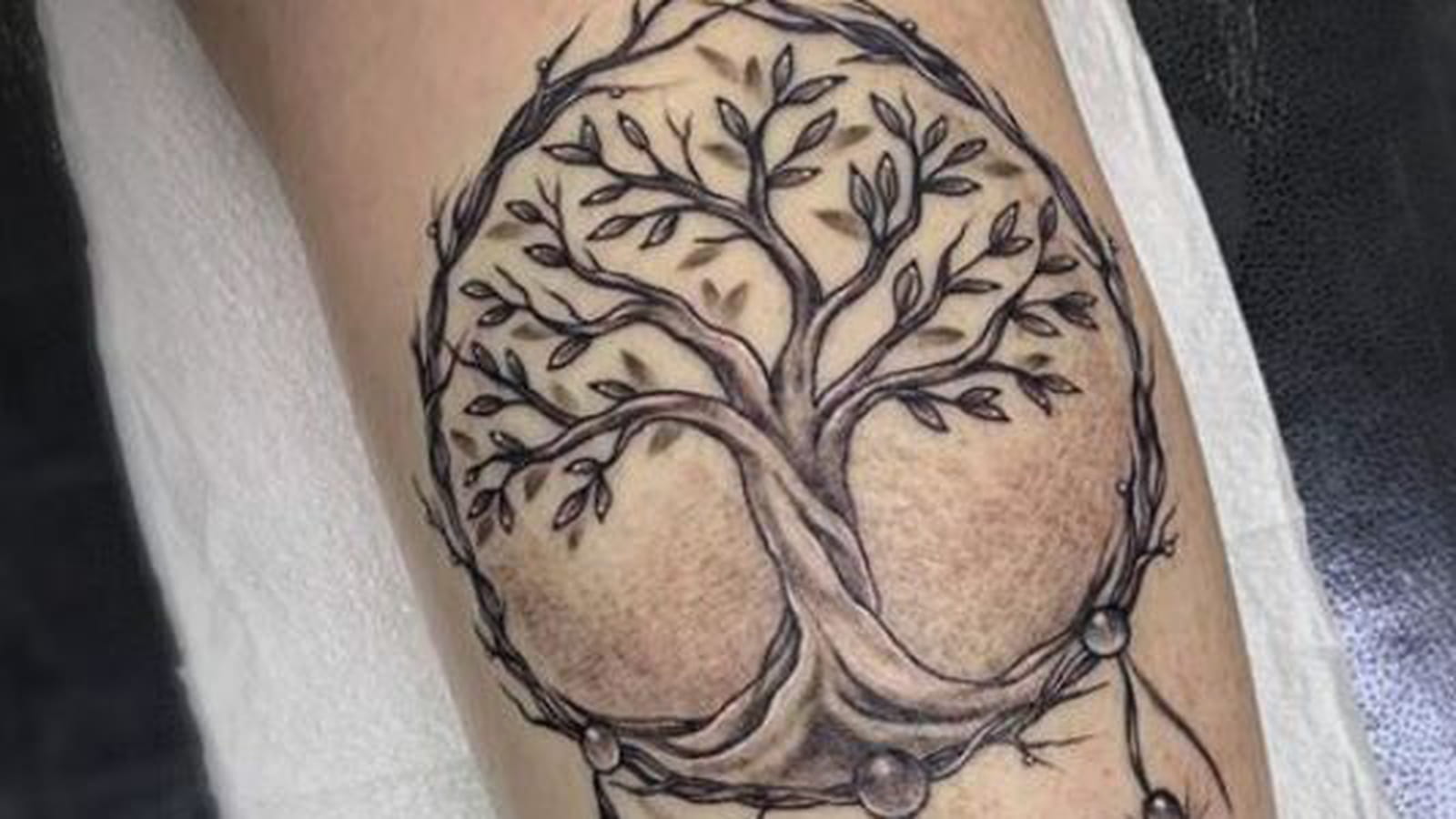 Arbre de vie et attrape-rêve sur le mollet