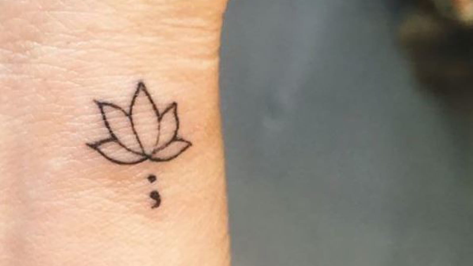 Point-virgule et fleur de lotus sur le poignet