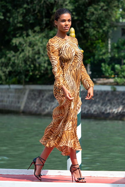 Tina Kunakey en robe fluide tigrée et escarpins noirs