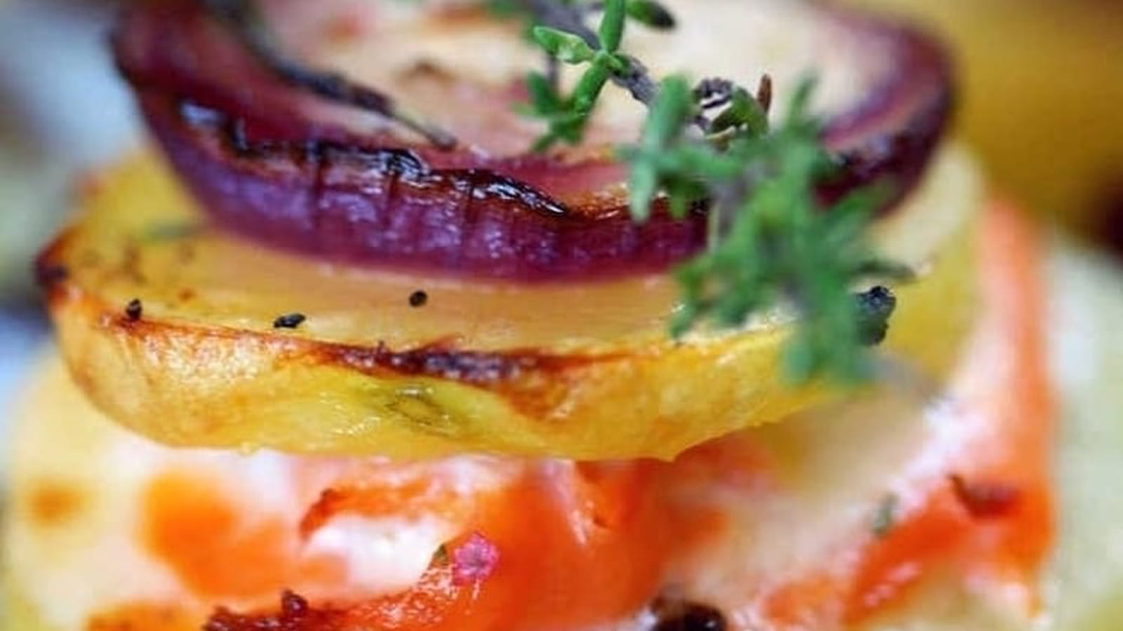 Mille feuilles de pommes de terre, truite fumée et oignons rouges caramélisés au miel de thym