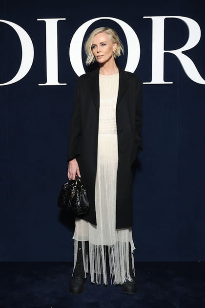 Charlize Theron en robe blanche &agrave; franges et manteau long en laine au d&eacute;fil&eacute; Dior
