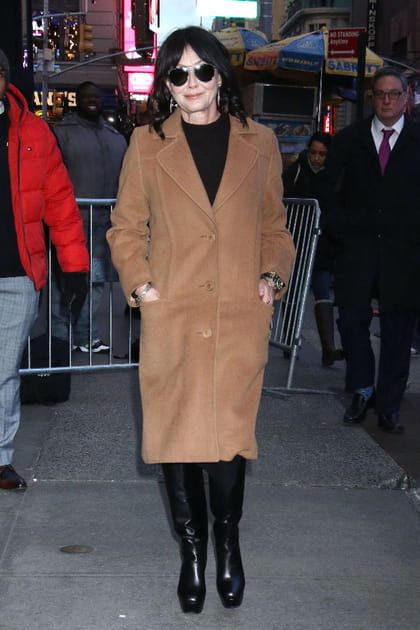 Shannen Doherty en long manteau camel et bottes noires