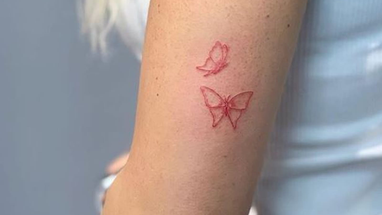 Papillons à l'encre rouge sur le bras
