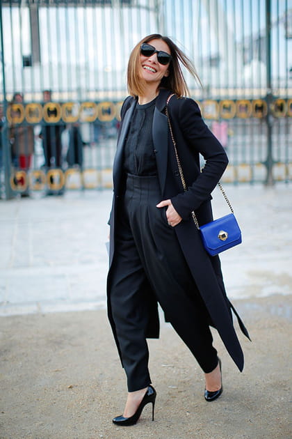 Clotilde Courau en pantalon noir et sac à main violet
