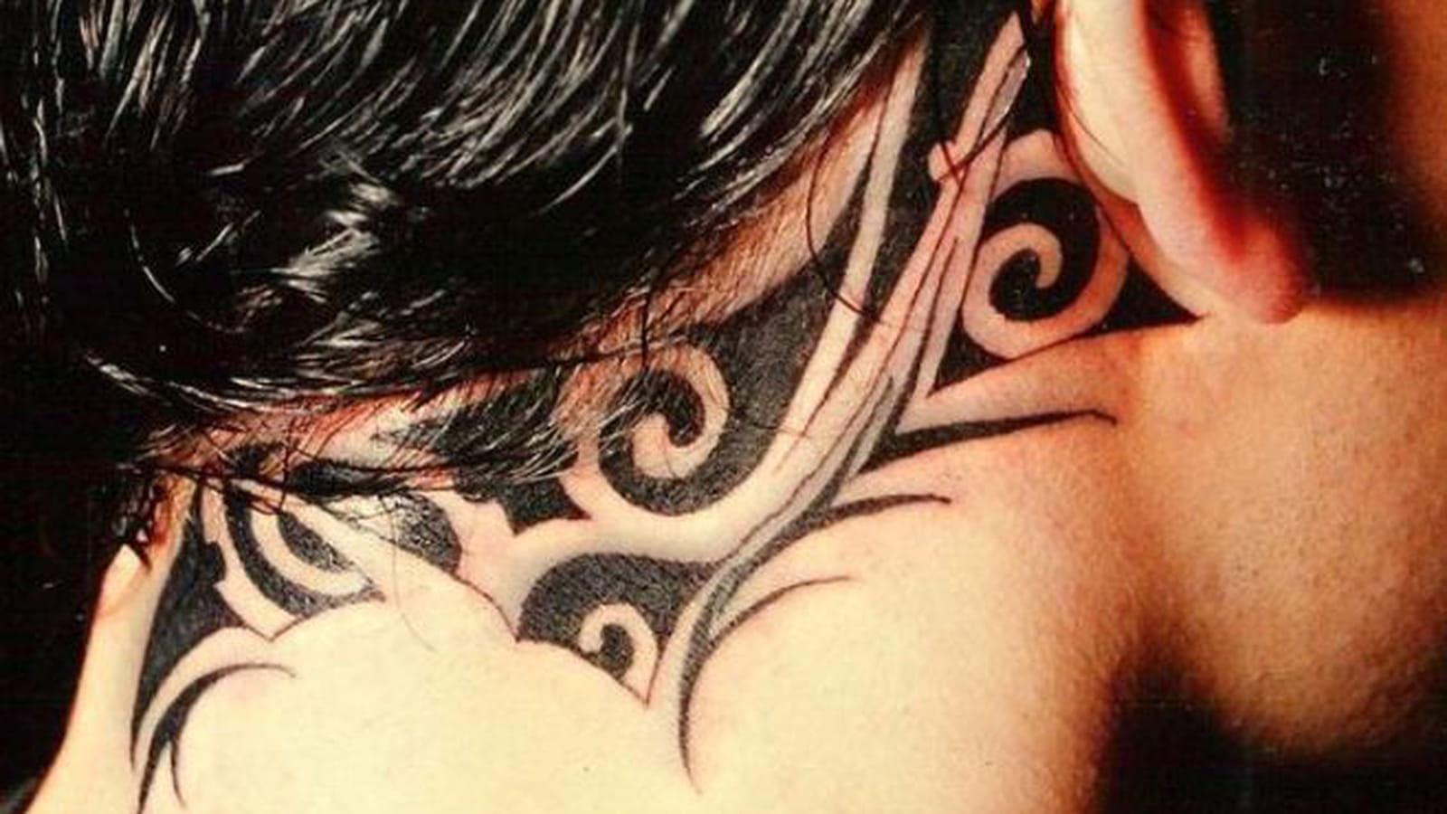 Tatouage tribal entre la nuque et l'oreille