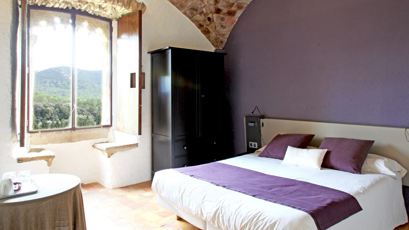 Une chambre violette sous les voûtes de pierres