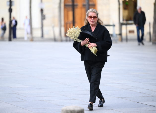 Catherine Deneuve, bouquet entre les mains, aux obs&egrave;ques de Jean-Paul Rappeneau