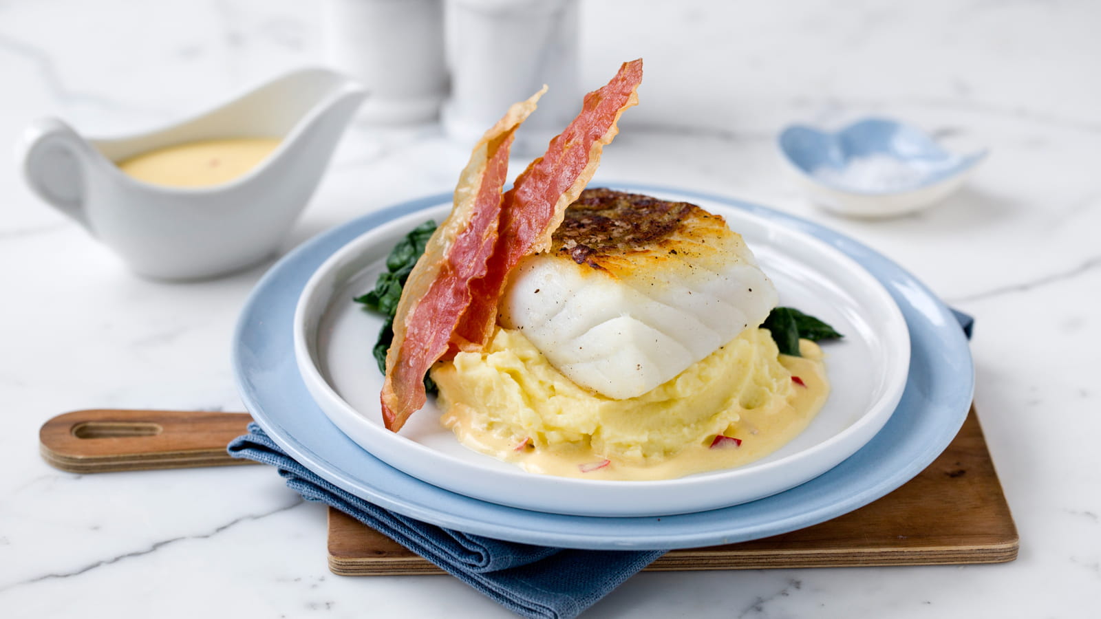 Skrei sur purée de pommes de terre, sauce à l'orange et chips de jambon de Parme