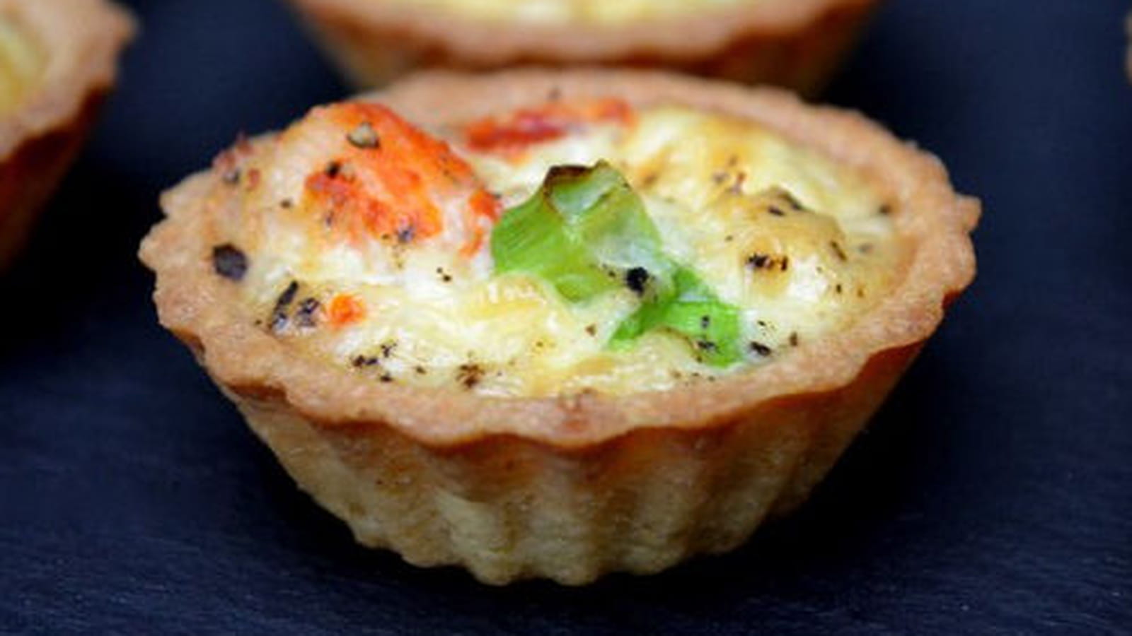 Mini quiches au crabe, fanes d'oignons nouveaux et curry