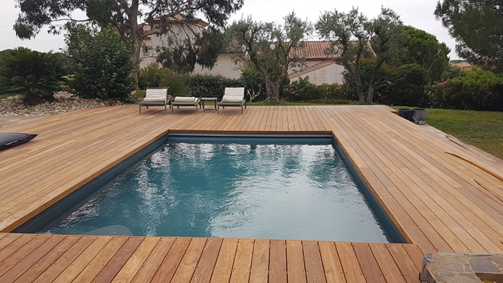 Une petite piscine carrée sur une grande terrasse