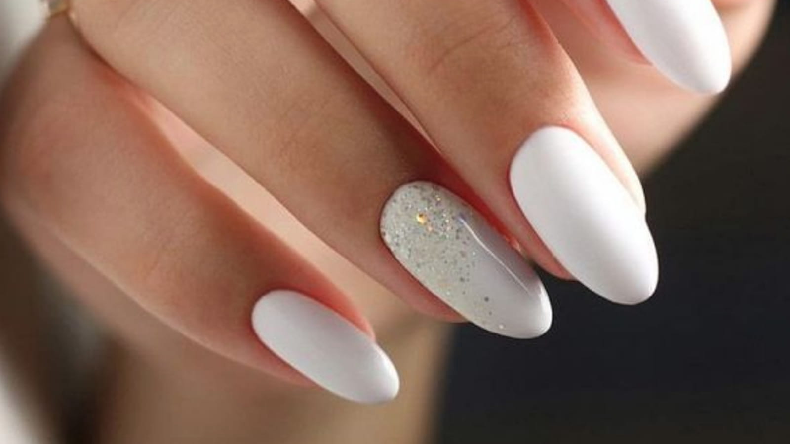 Des ongles blancs avec un ongle pailletté