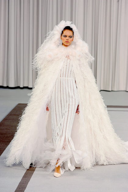 Silhouette Chanel en robe blanche semi-transparente et cape à plumes