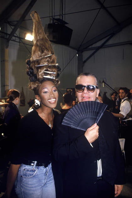 Naomi Campbell en chemisier noir et jean bleu clair