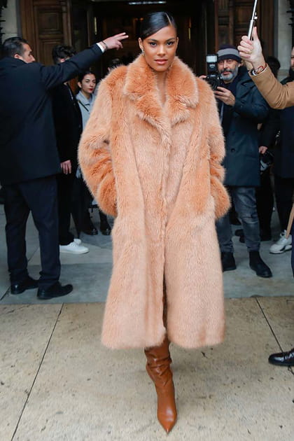 Tina Kunakey en manteau en fourrure saumon et bottes camel en cuir Stella McCartney