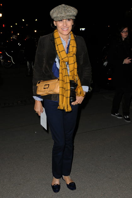 Inès de la Fressange en pantalon bleu marine, veste noire et &eacute;charpe jaune