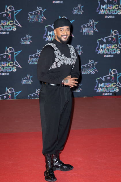 Slimane dans un look noir accessoiris&eacute; d'un bijoux de buste