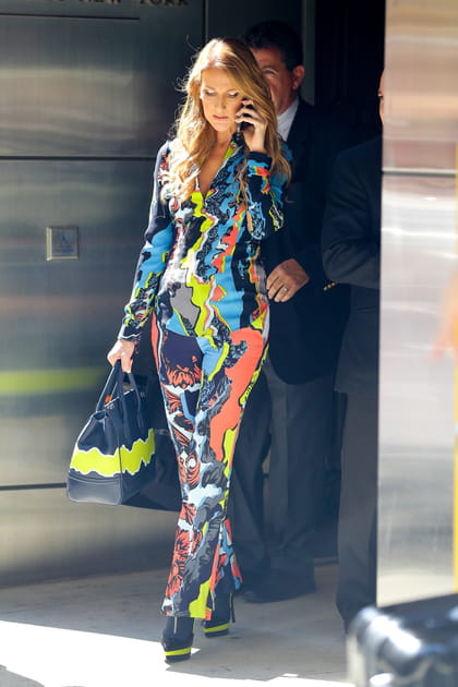 Céline Dion en combinaison multicolore Versace et sac à main noir et jaune fluo